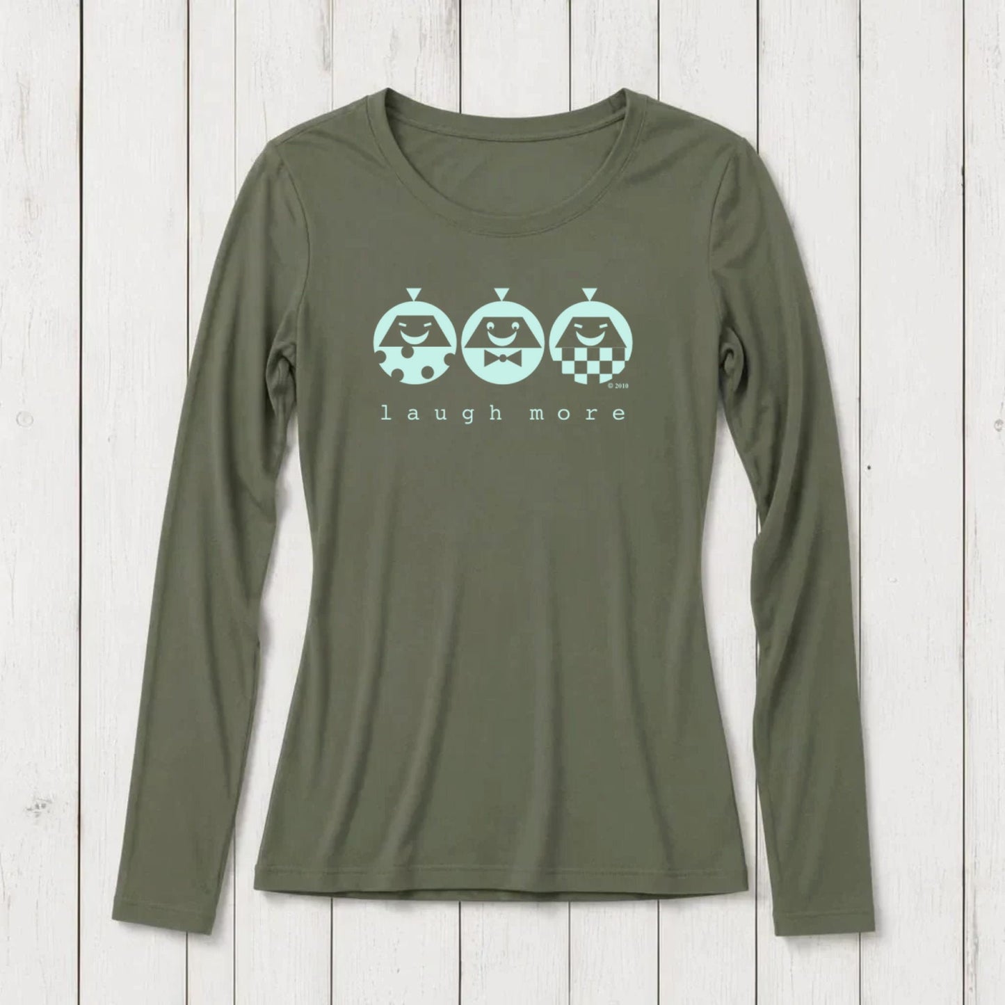Olive green long sleeve T-shirt with playful graphic of three smiling characters and the phrase 'laugh more' printed below, made from soft cotton blend, casual wear for women.