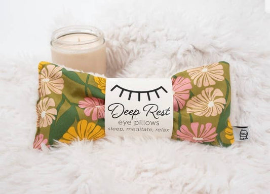 Deep Rest Eye Pillow on fluffy surface beside a candle, ideal for relaxation, stress relief, and meditation routines.