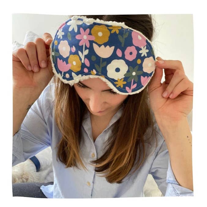 Woman wearing Sweet Dreams Sleep Mask by Little Man with blue floral cotton front, ideal for relaxation and restful sleep at home.