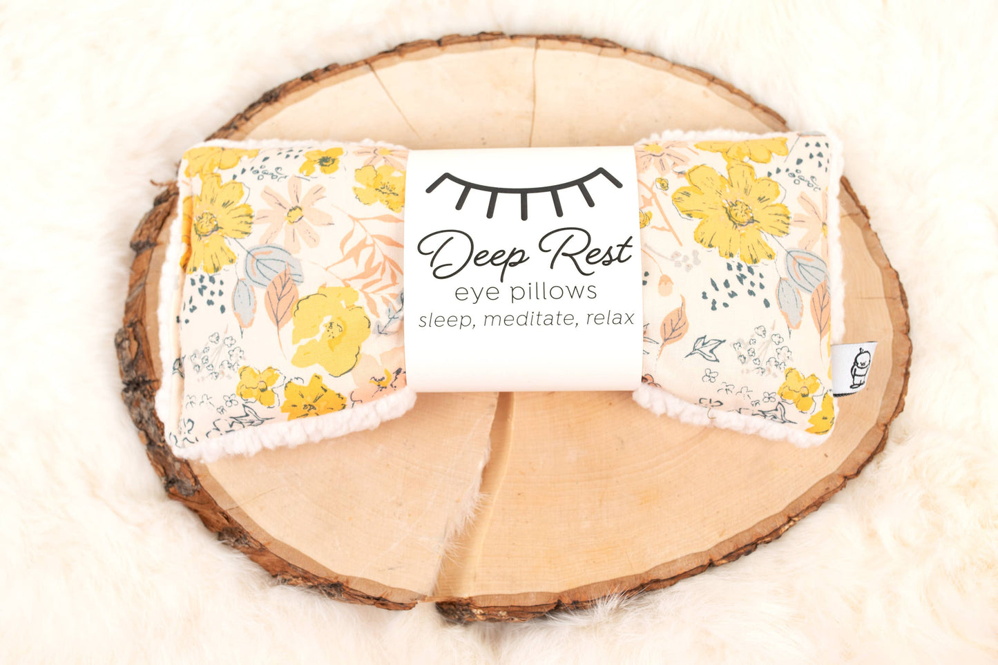 Deep Rest Eye Pillow - Relaxation & Sleep Aid with yellow floral pattern, displayed on rustic wood and fur for cozy home decor appeal.