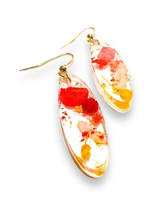 Oval resin earrings with red and yellow real flowers and gold hooks. Nature-inspired pressed flower earrings for a vibrant look.