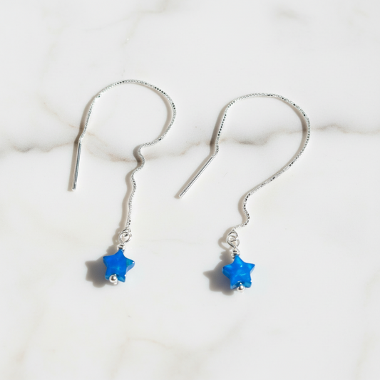Threader earrings with blue star charm on white background