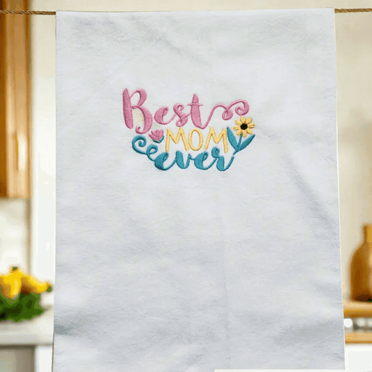 Best Mom Ever Towel - Embroidered Gift | Flour Sack 27"x27" hanging in a cozy kitchen, showcasing colorful embroidery for Mother's Day or birthdays.