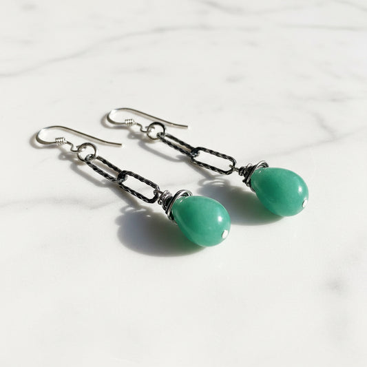 Close-up of silver chain earrings with green chalcedony drops