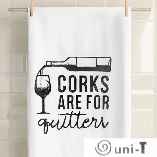 Corks are for Quitters Towel - Fun Kitchen Accessory hanging on a tiled wall. Embroidered design adds charm to any kitchen decor.