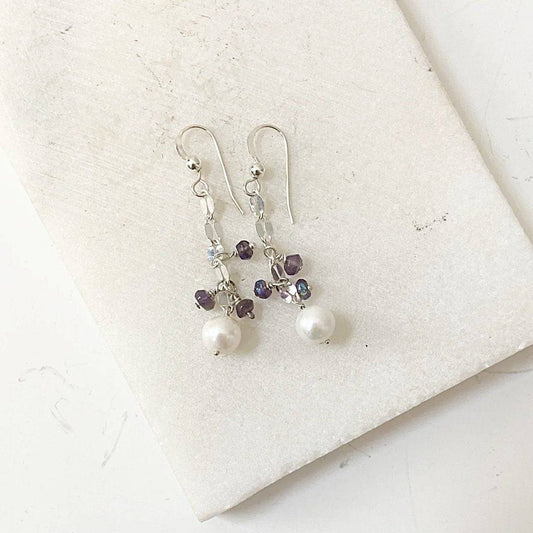 Cultured Pearl Earrings - Amethyst | Sterling Silver displayed on a white marble surface, featuring dangling pearls and purple amethyst beads.