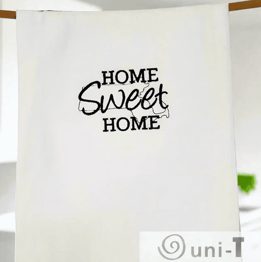 Massachusetts Embroidered Towel hanging neatly, featuring 'Home Sweet Home' text with state outline. Perfect for stylish kitchen organization.