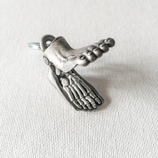 Anatomical Human Foot Keychain opened to reveal detailed skeletal structure. Unique accessory for medical or anatomy enthusiasts.