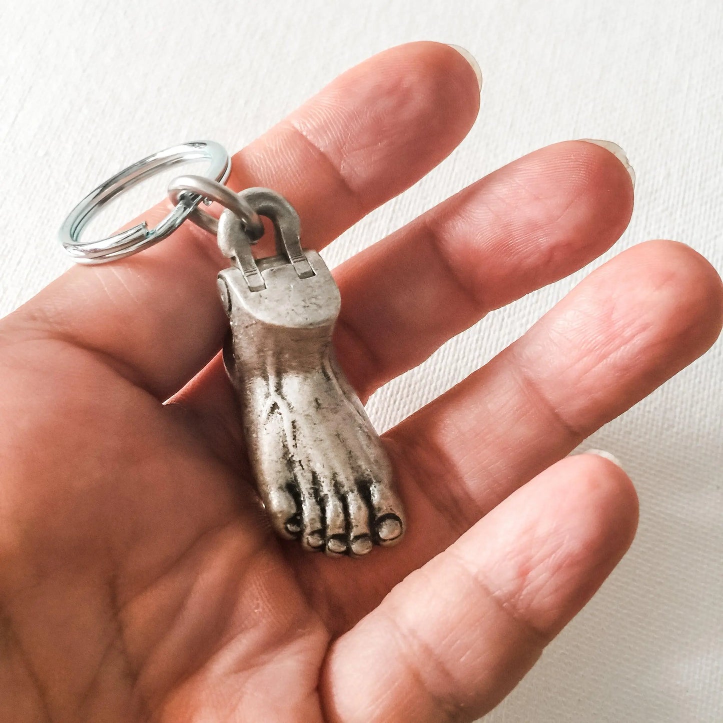 Compact Anatomical Human Foot Keychain held in hand, showcasing realistic design. Perfect for collectors and anatomy enthusiasts.