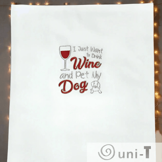 Wine Dog Embroidered Towel displayed flat with fairy lights; fun kitchen towel gift for wine enthusiasts and pet owners.