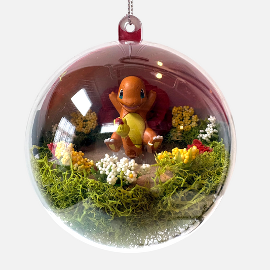 Uni-T Pokeball terrarium ornament featuring a Charmander figure inside a clear plastic sphere with moss and flowers