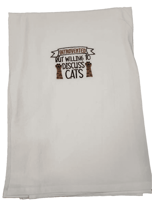 Folded embroidered kitchen towel featuring cat paw design and humorous quote, ideal for introverted cat lovers seeking fun kitchen linens.