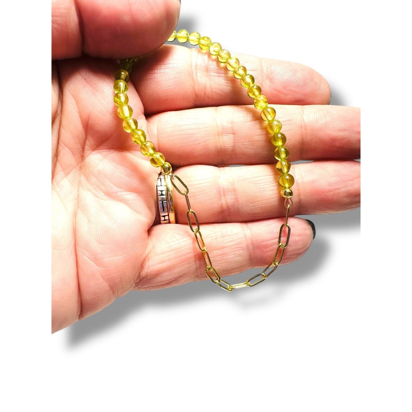 Close-up of yellow gemstone bracelet with gold chain