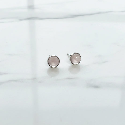 Close-up of rose quartz earrings on floral display card