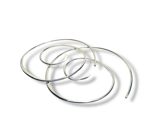 Silver Swirl Hoops - Set of sterling silver swirl earrings shown overlapping on a white background. Sleek, modern hoops for stylish accessorizing.