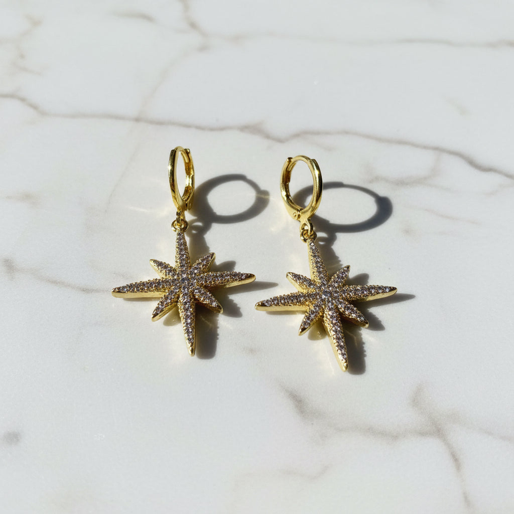 Gold star-shaped hoop earrings with glittering star pendants
