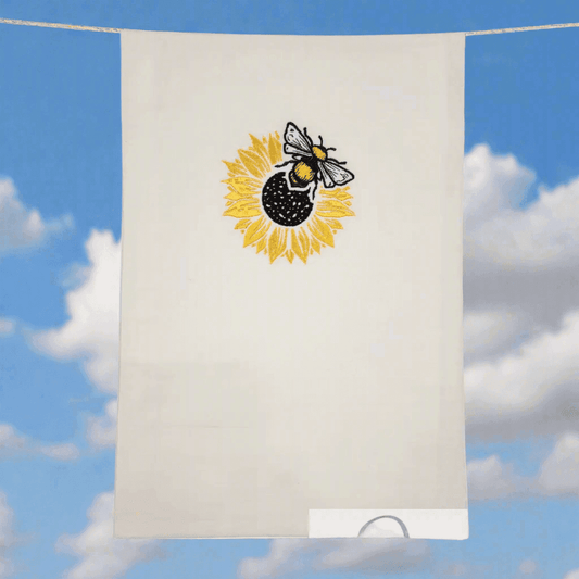 Sunflower Bee Embroidered Towel hanging outdoors against blue sky, showcasing vibrant embroidery ideal for kitchen or gift use.