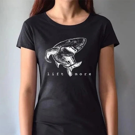 Black fitted women's shark graphic T-shirt with 'Lift More' slogan. Bamboo and organic cotton blend for sustainable gym wear.