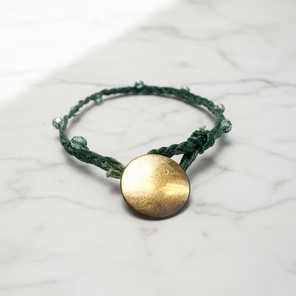 Red braided cord bracelet with gold medallion