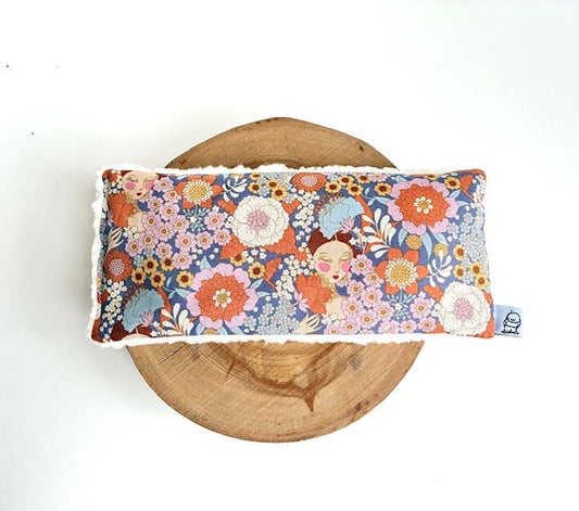 Floral eye pillow on wooden surface for relaxation