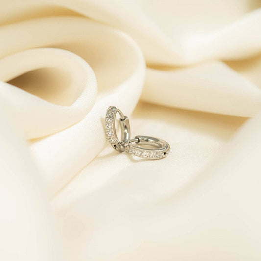 Mini Huggie Earrings with diamonds on white satin
