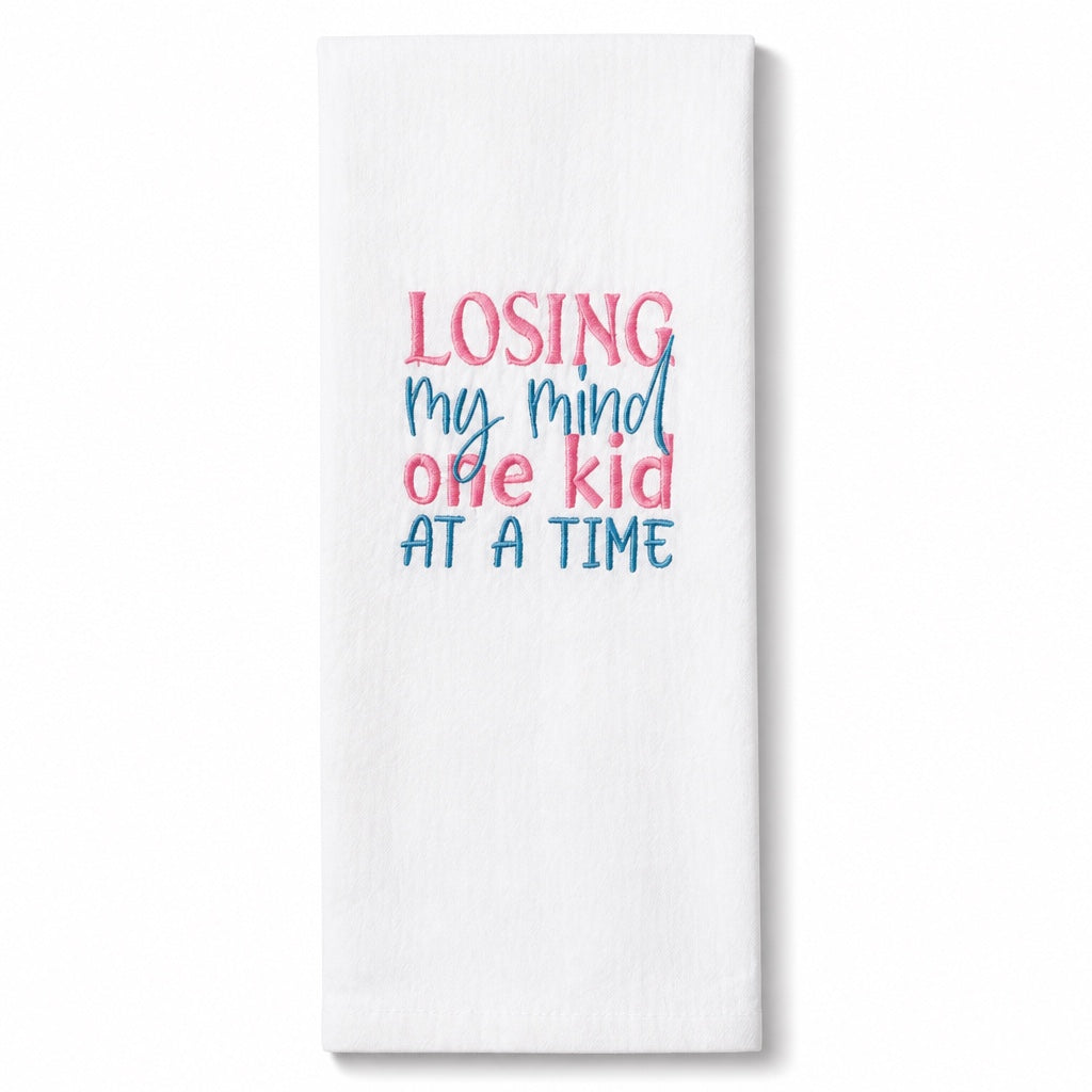 Uni-T white flour sack kitchen towel with pink and blue embroidered text reading Losing my mind one kid at a time