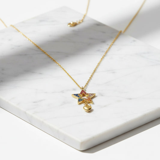 Front view of Cubic Zirconia Star Necklace on gold chain, showcasing rainbow-colored stones and a gold heart charm for versatile styling.