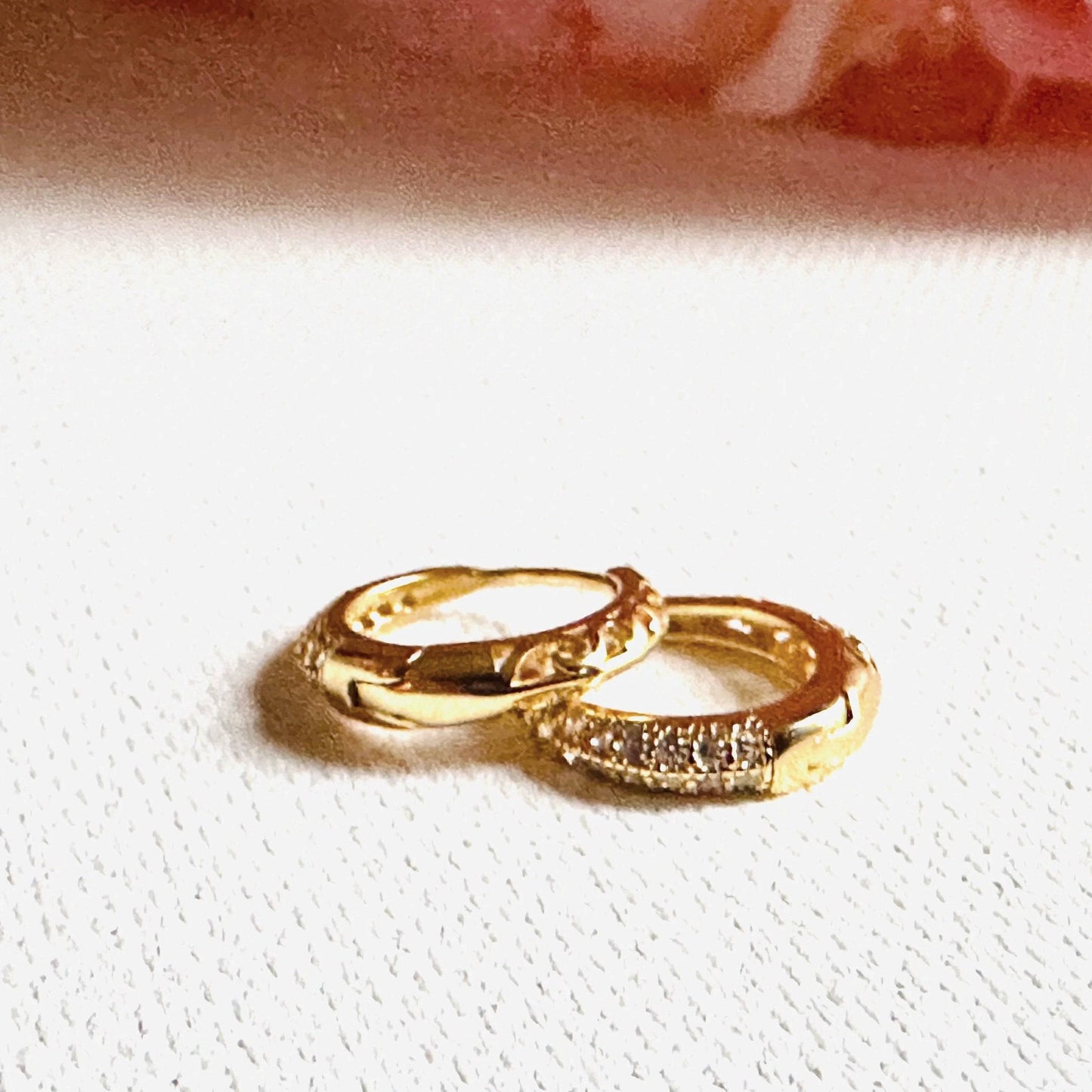 Gold huggie hoop earrings with crystal accents and polished finish. Ideal for elevating any outfit with a touch of shine.