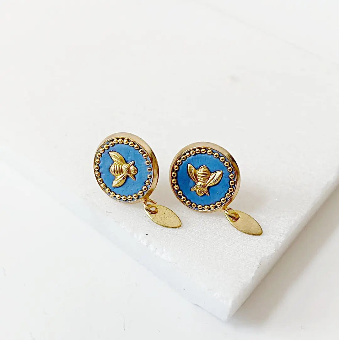 Elegant bee stud earrings in brass with blue crystal and gold bee detail, ideal for all-day wear and unique accessory collections.