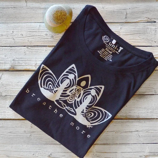 Folded black women's bamboo and organic cotton long sleeve T-shirt with 'Breathe More' graphic. Cozy mindfulness gift for yoga and self-care lovers.