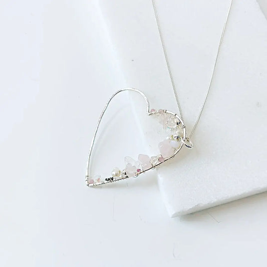 Sterling silver heart-shaped necklace featuring delicate crystals and pearls. Unique silver gemstone jewelry gift for her.