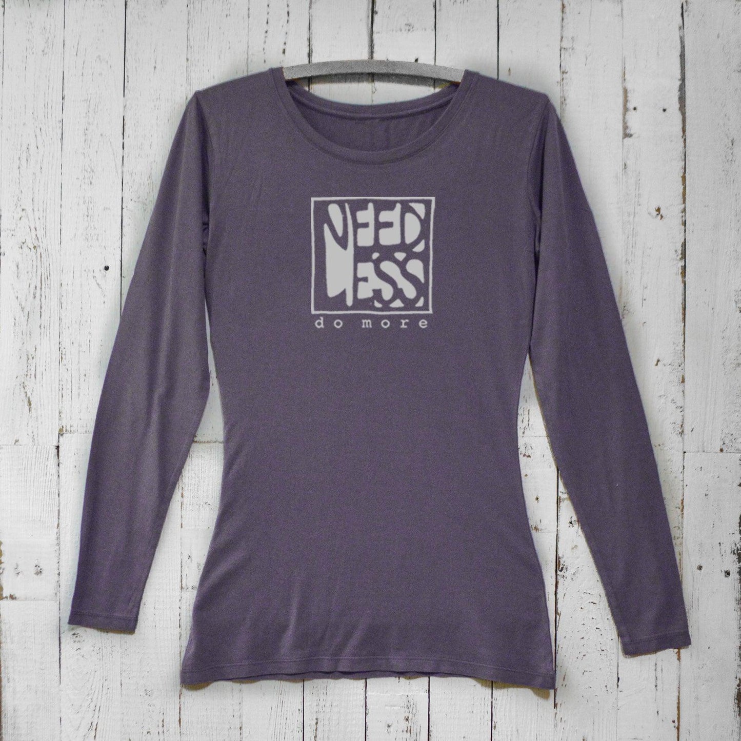 Dark purple women's bamboo and organic cotton long sleeve shirt with 'Need Less Do More' design. Eco-friendly minimalist apparel by Uni-T.