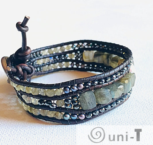 Multi gemstone cuff bracelet with leather wrap, showcasing labradorite, pearls, and faceted beads for a bold, elegant accessory.