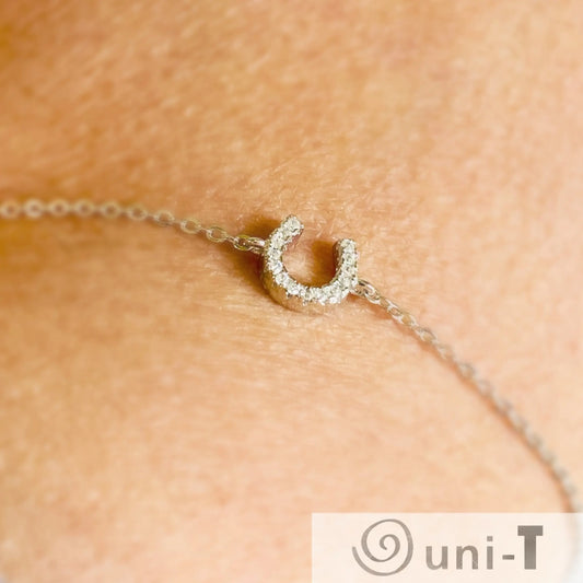 Sterling silver Luck Bracelet with rhinestone horseshoe charm shown on wrist. Elegant and adjustable for a secure, stylish fit.