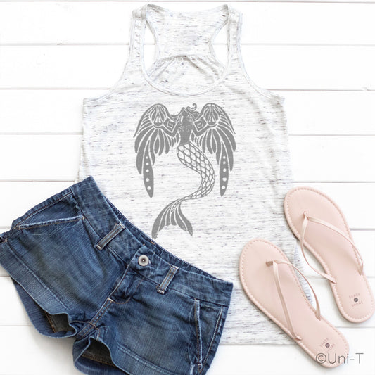White speckled flowy tank top for women with grey mermaid design, styled with denim shorts and sandals. Lightweight and eco-conscious fabric.
