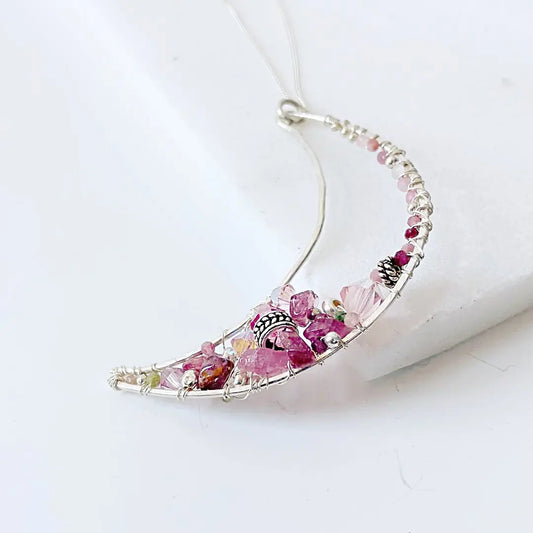Close-up of Sterling Silver Moon Necklace featuring hand-wrapped pink gemstones and pearls on a delicate 18” box chain.