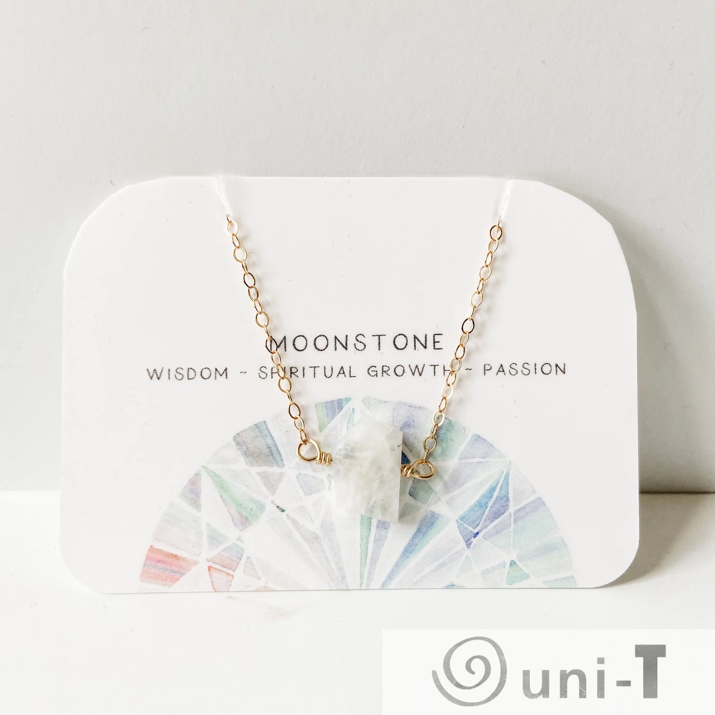Moonstone gemstone necklace on display card with spiritual meaning, featuring gold-filled chain and hand-cut moonstone pendant by Uni-T.