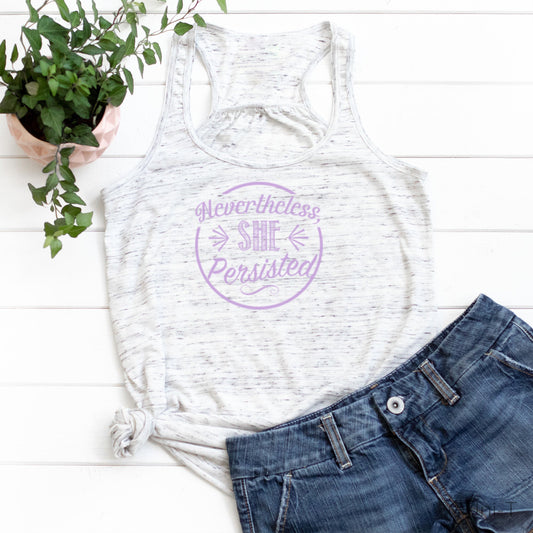 White marbled racerback tank top with purple 'Nevertheless She Persisted' print. Feminist tank styled with denim shorts for casual empowerment.