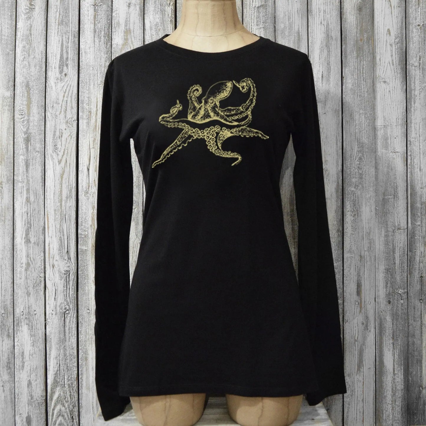 Fitted black Women's Octopus Long Sleeve T-Shirt on mannequin, made of bamboo and organic cotton with gold sea life graphic for eco-conscious style.