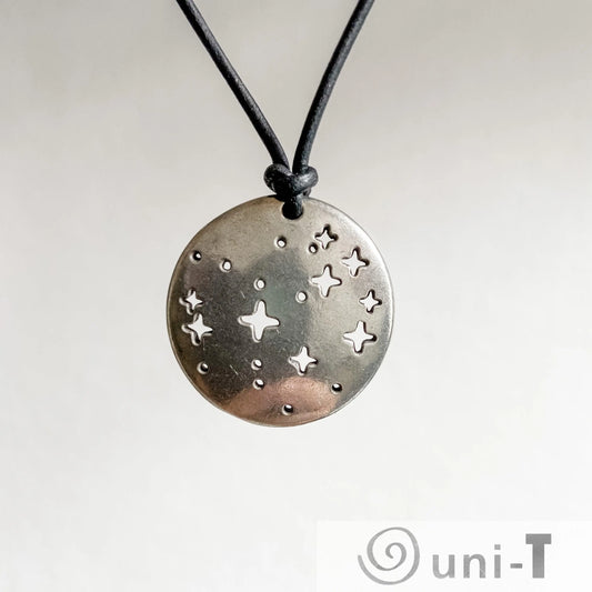 Close-up of Pleiades Pendant - Pleiades Constellation Necklace featuring star-shaped cutouts on a round pewter charm. A celestial science jewelry piece.