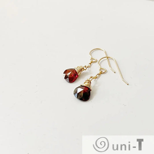 Gold-filled earrings with red teardrop CZ stones, wire-wrapped and lightweight. Stylish 1 inch long dangle design for versatile wear.