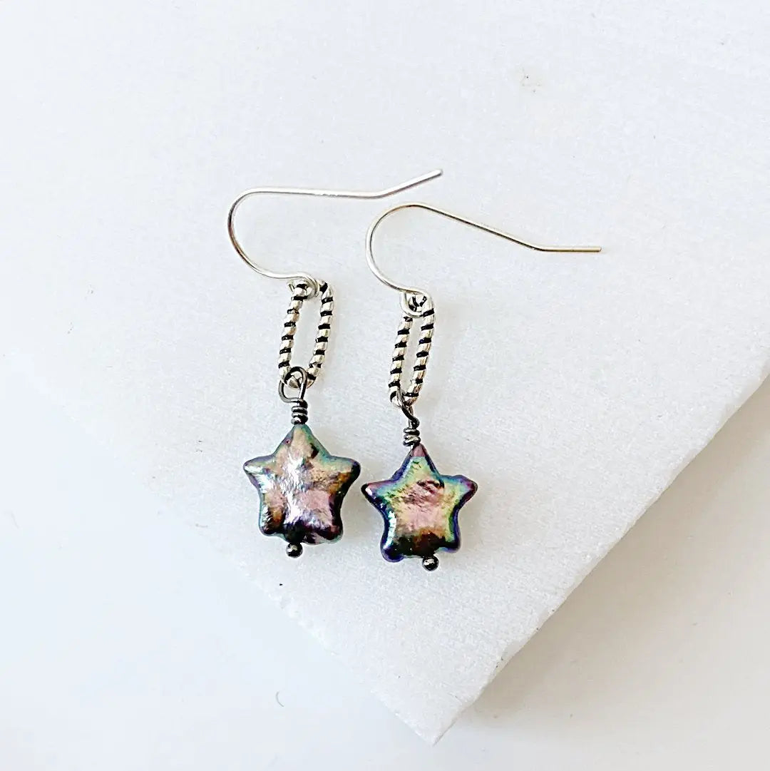 Iridescent star-shaped freshwater pearl earrings with vintage-style silver loops. Handmade jewelry perfect for gifting or styling.