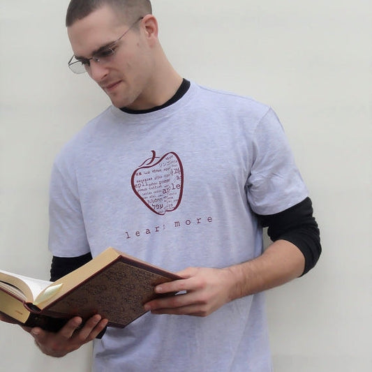 Man wearing grey Uni-T Inspirational Graphic Tee with multilingual apple design and 'learn more' slogan, classic fit teacher gift.