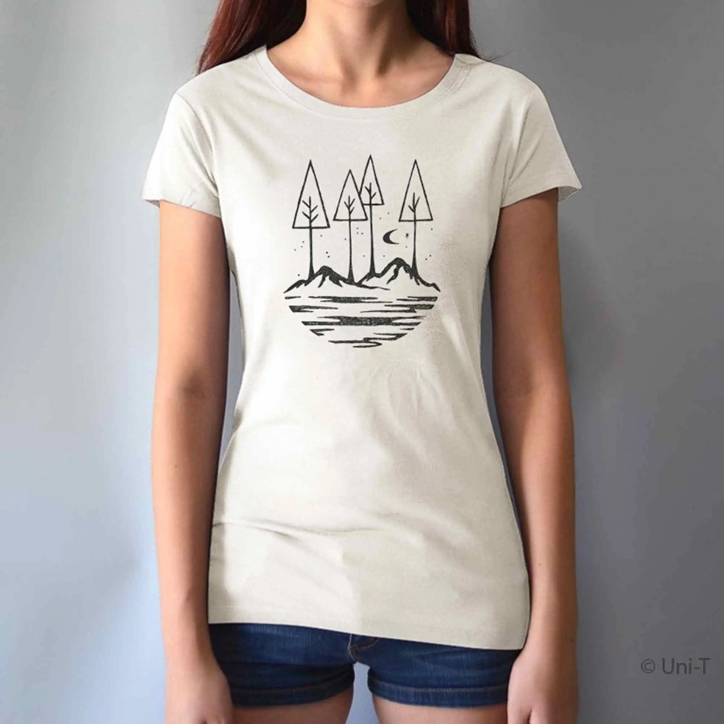 Cream-colored women's t-shirt with black forest and mountain print. Made from bamboo and organic cotton for sustainable outdoor style.