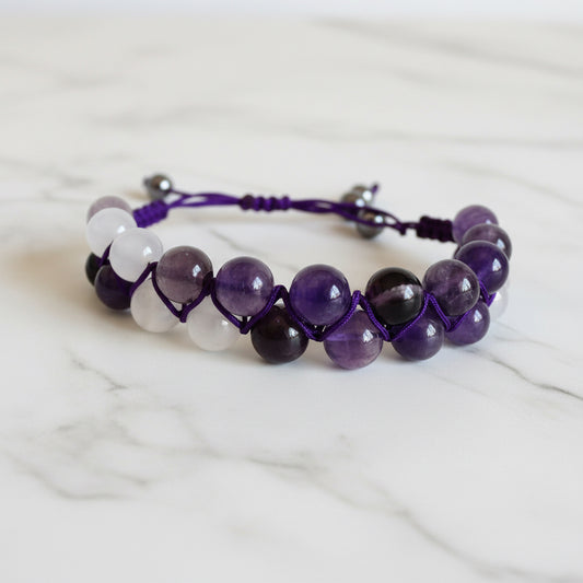Purple and white gemstone woven bead bracelet with adjustable purple nylon cord. Ideal for fashion-forward, spiritual styles.