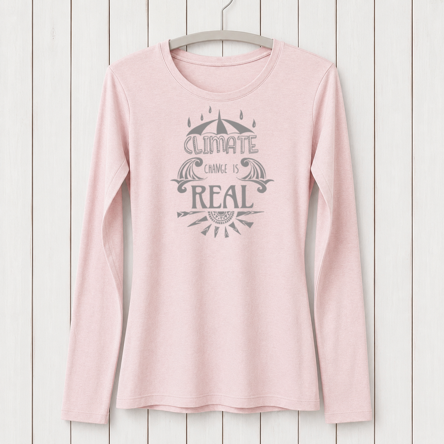 Light pink women's long sleeve T-shirt made from bamboo and organic cotton with a climate change awareness graphic, hanging on a white wooden wall