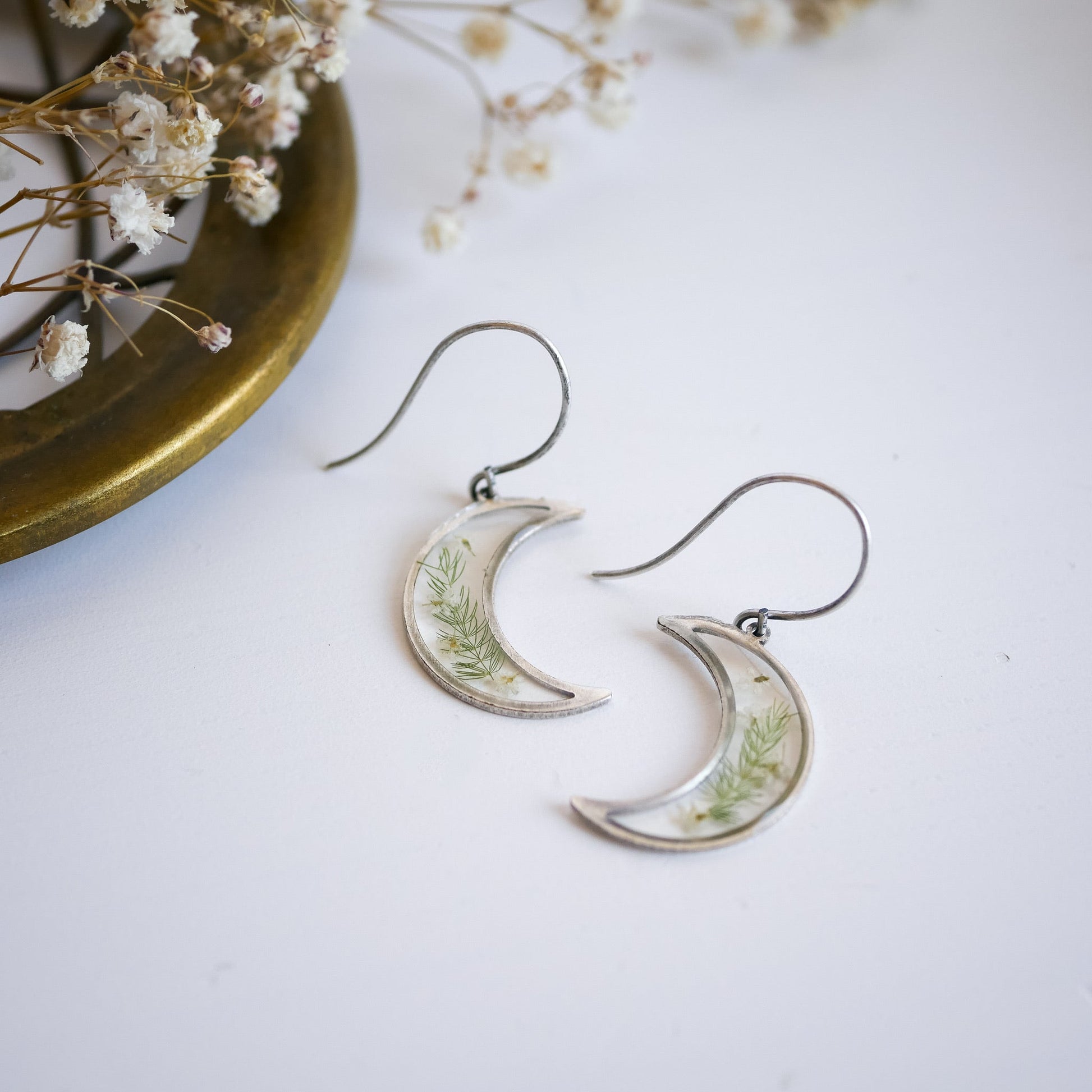 Pair of silver Garden Flower Earrings with Queen Annes Lace. Crescent moon shape with botanical elements, ideal for floral jewelry collections.