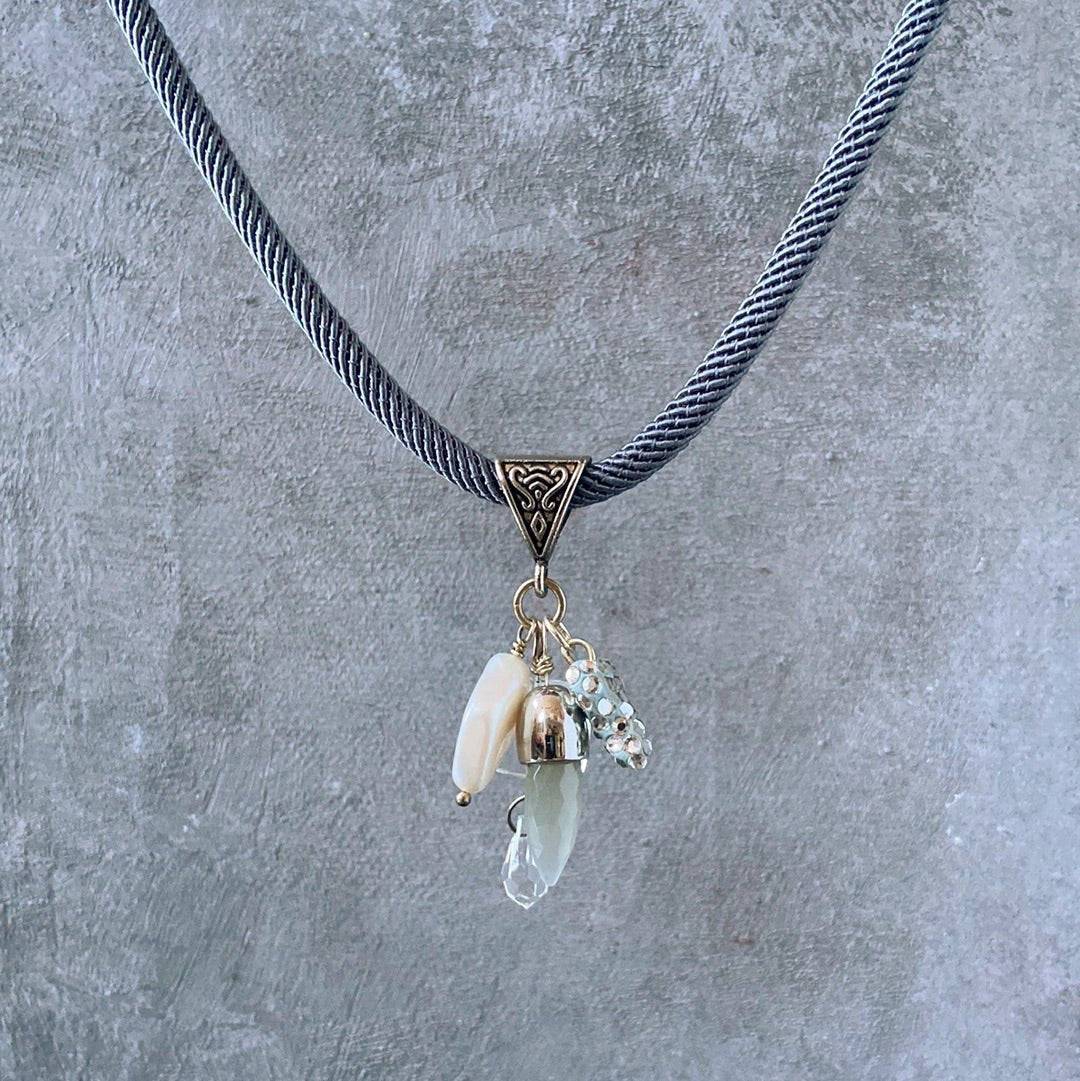 Heart and Pearl Charm Necklace-Uni-T featuring clustered charms including pearl, crystal, and quartz on a textured grey cord. Chic accessory for any outfit.