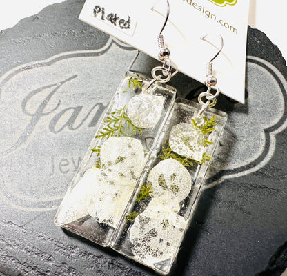Rectangular resin earrings with white flowers and greenery and silver hooks. Elegant pressed flower earrings with a clean design.