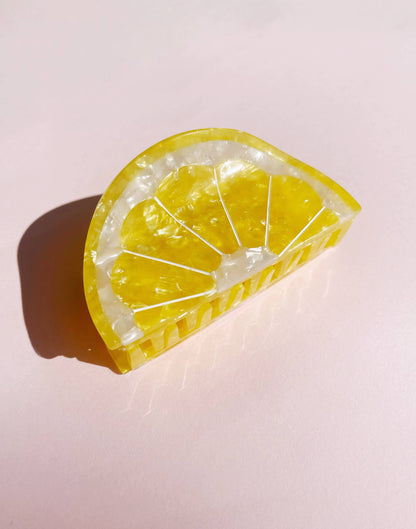 Close-up of Sunshine Yellow Lemon Claw Hair Clip with pearlescent texture, ideal for stylish summer hairdos and beach-ready looks.